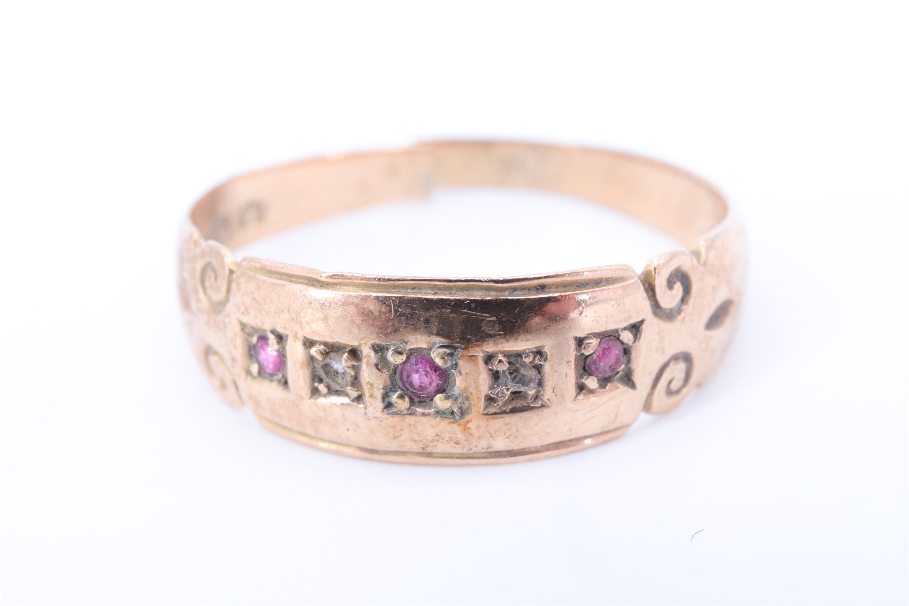 A late Victorian ruby and diamond ring, the stones gypsy set in a line between adorsed scroll - Image 5 of 6
