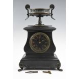 A late 19th Century black slate mantle clock, having a drum movement, the case being of bombé form