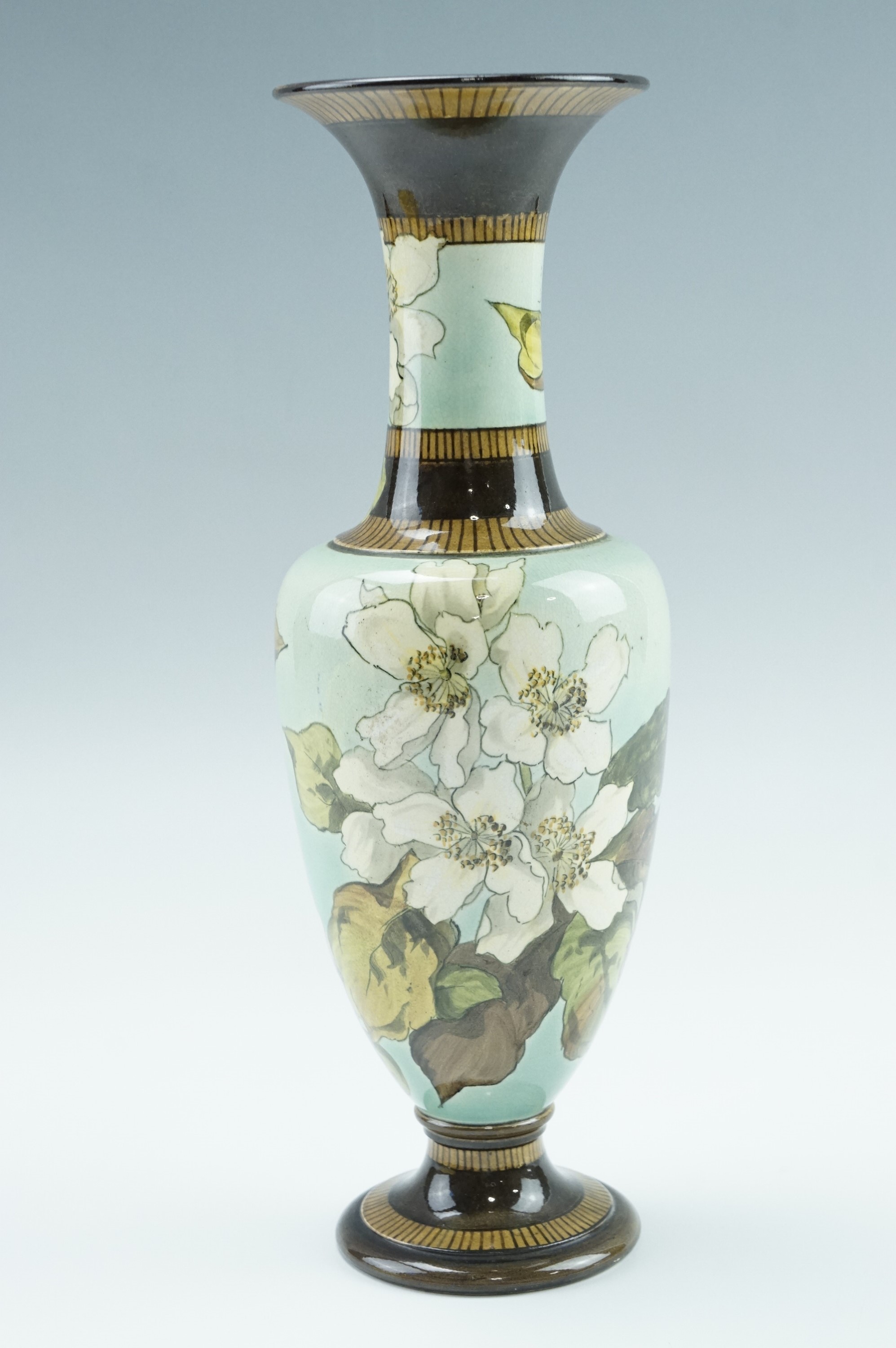 A late 19th Century Doulton Lambeth Faience vase, of slender urn form having an elongated neck and