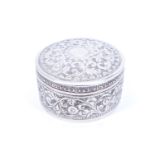 An Indian white metal cylindrical table box, bearing foliate scroll decoration, struck mark to the