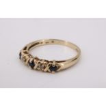 A sapphire and white stone ring, the small stones divided by saltire bars on a 9 ct gold shank, M,