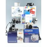 A group of digital cameras, including a boxed Olympus "TG-320" and "Camedia C-720", and a boxed
