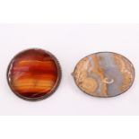 Two mid to late 20th Century white metal mounted agate brooches, respectively being a banded agate