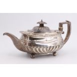 A George IV silver teapot, of compressed form decorated with gadrooning, bearing an engraved