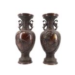 A pair of 20th Century oriental cast bronze two handled vases, of urn form having everted necks