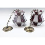 A pair of wrought metal and coloured glass pendant light fittings