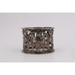 A Victorian silver napkin ring, having pierced and embossed decoration of putto either side of a