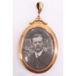 An Edwardian 9 ct yellow metal double locket, the oval frame having an adorsed scroll crest on a