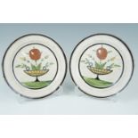 A pair of 19th Century hand enamelled earthenware plates, 22.5 cm