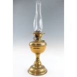 An early 20th Century brass oil lamp having a 1" duplex burner, 56 cm including chimney