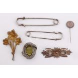 Two white metal filigree brooches, a 1/2 frank coin stick pin, a costume brooch and two kilt pins,