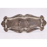 A Belle Époque American white metal pin tray, having embossed decoration and an engraved monogram,