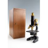 A cased black lacquer and cast iron monocular triple turret microscope by Bausch & Lomb Optical