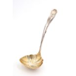 An early 20th Century American white metal sauce ladle, having a parcel gilt scalloped bowl, the