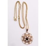 A 9 ct gold, garnet and pearl pendant necklace, the 4 mm garnet surrounded by six pearls, in turn