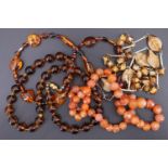 A vintage amber necklace, comprising baroque beads of alternating sizes, together with three costume