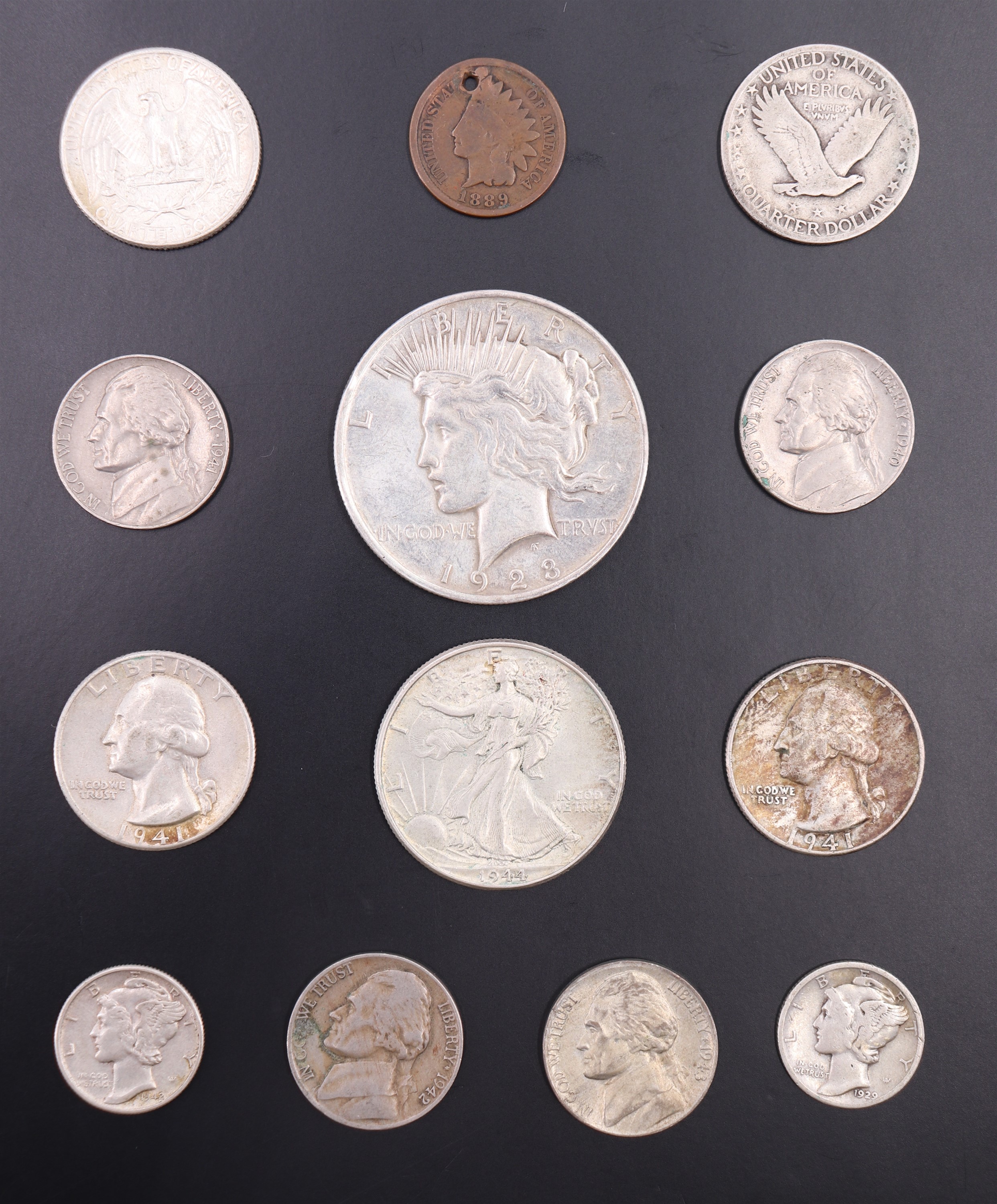 A group of US silver coins, including a 1923 "Peace" dollar, a 1944 "Walking Liberty"half dollar,