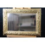 An early 20th Century gilt mirror with laurel moulded decorated frame, 72 cm x 52 cm overall