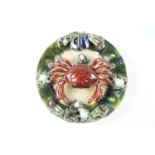 A Palissy style majolica plate decorated in depiction of a crab on a beach, indistinguishable