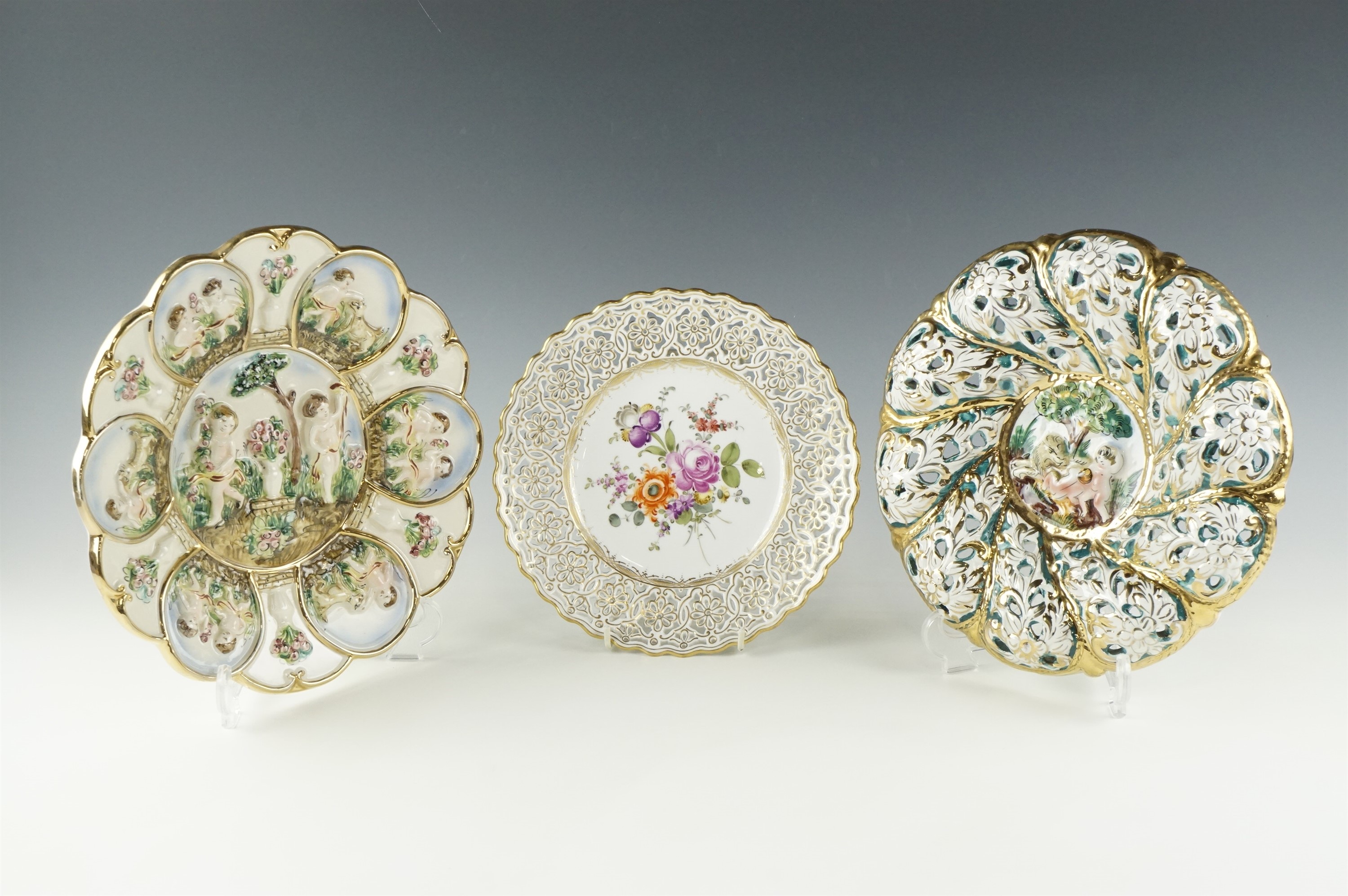 A late 20th Century Meissen hand enameled and gilt plate with a reticulated rim, together with two