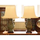 A pair of patinated bronze table lamps in the form of archaic Chinese vessels, 42 cm excluding stem,