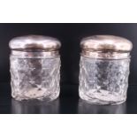 A pair of George V silver topped cut glass dressing table containers, having star and diamond