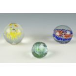 A Caithness "Pebble" glass paperweight together with a Murano and one other paperweight, tallest 8