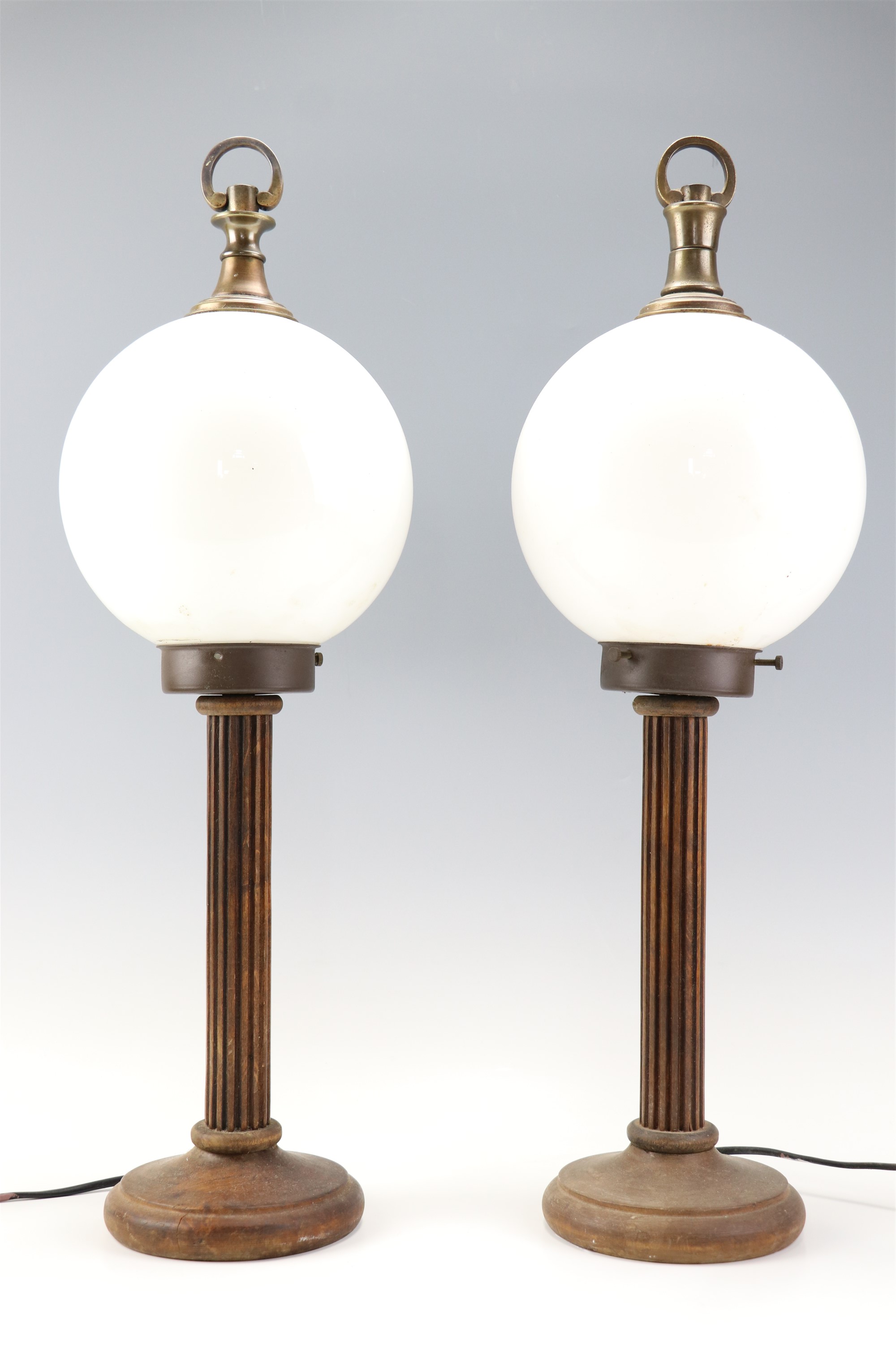 A pair of columnar wooden table lamps having glass globe shades, 61 cm