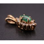 A modern emerald and yellow metal pendant, the marquise stone claw set above 12 surrounding white