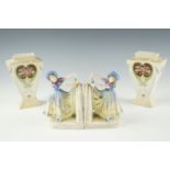 A pair of 1920s figural ceramic book ends, modelled as a girl lifting her hem, marked '37144' to the