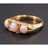 An early 20th Century opal and diamond ring, having three graduated opal cabochons (4 mm and 5