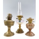 A brass oil lamp, having an amethyst glass reservoir, together with a "Super Aladdin" oil lamp and