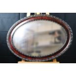 A 1920s oval bevelled-edged wall mirror in moulded frame, 90 cm x 64 cm overall