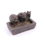 A Chinese cast bronze study of three pigs at a trough, the base bearing a punched two character