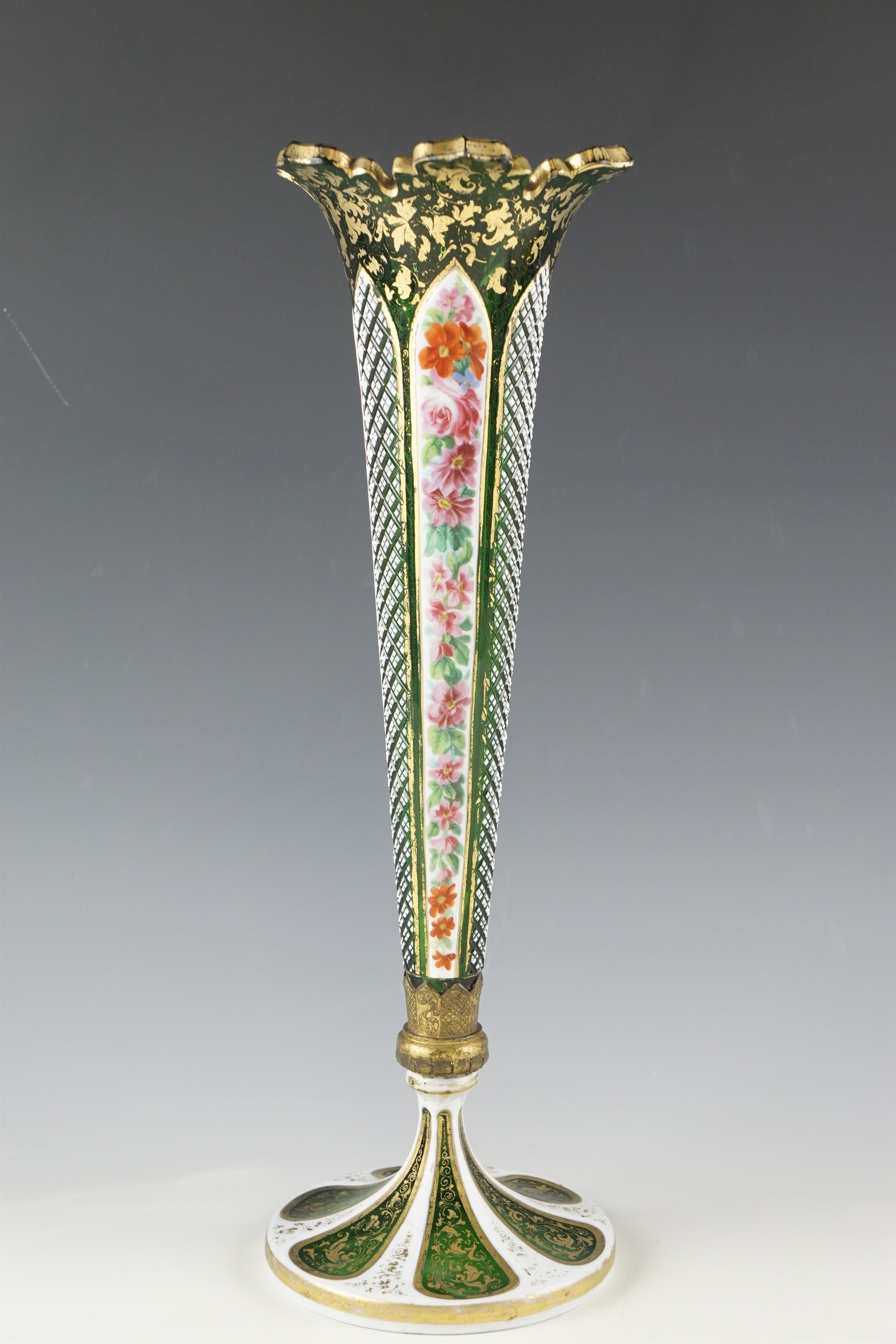 An early 20th Century emerald and white Bohemian glass vase, of trumpet form having panels of