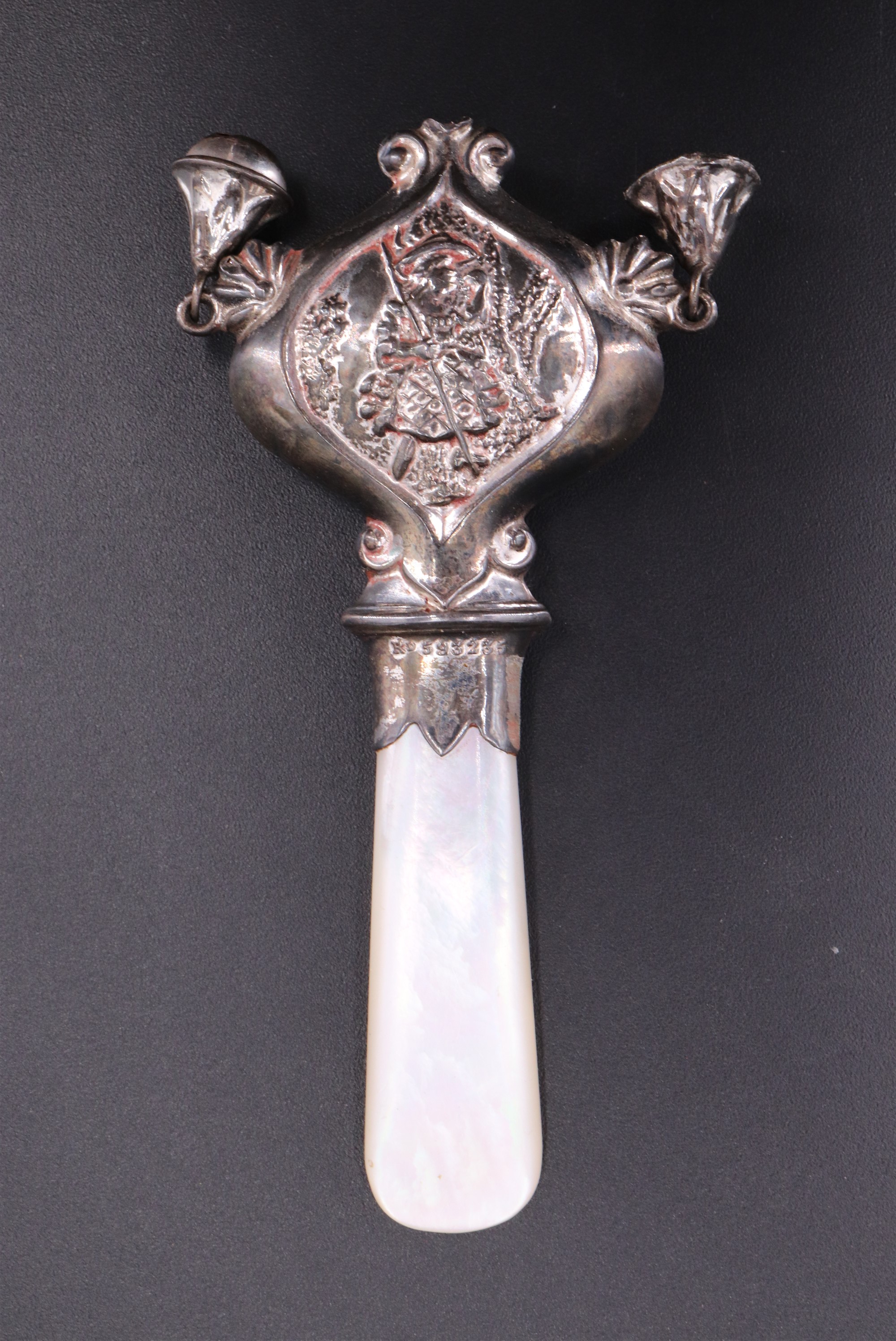 An infant's mother-of-pearl and white metal combined soother and rattle, registered design 593235,