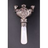 An infant's mother-of-pearl and white metal combined soother and rattle, registered design 593235,