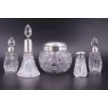 Four early 20th Century silver mounted scent bottles together with a silver mounted lidded pot of
