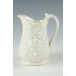 A Belleek cream jug, relief decorated with Bacchus masks and grape vines, (free from damage and