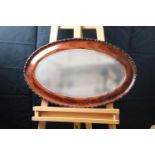 A George V oval bevel-edged wall mirror, 73 cm x 46 cm