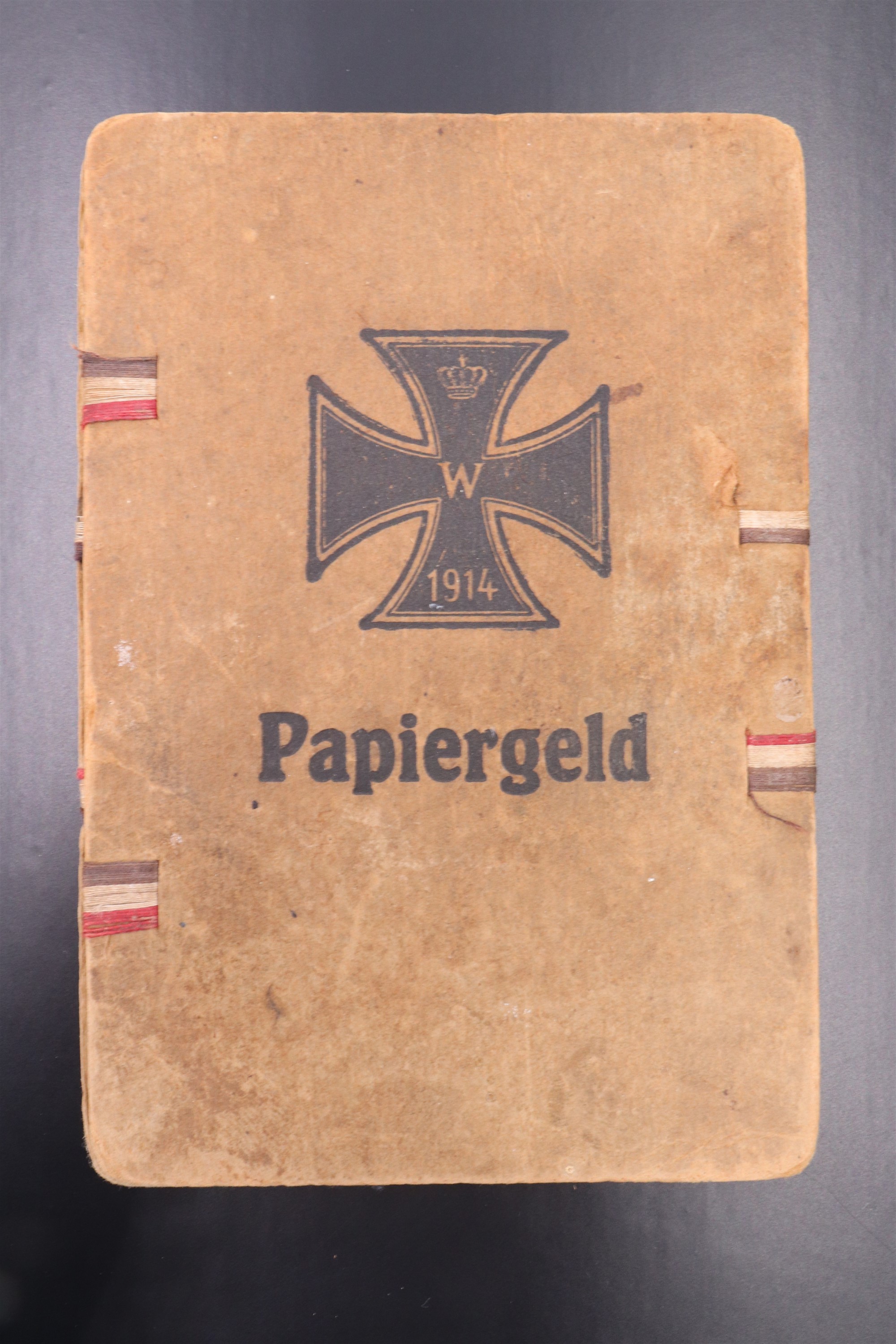 A Great War German printed card banknote wallet, its cover printed in depiction of a 1914 Iron Cross