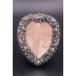 An early 20th Century embossed silver faced photograph frame, heart shaped and of diminutive size,