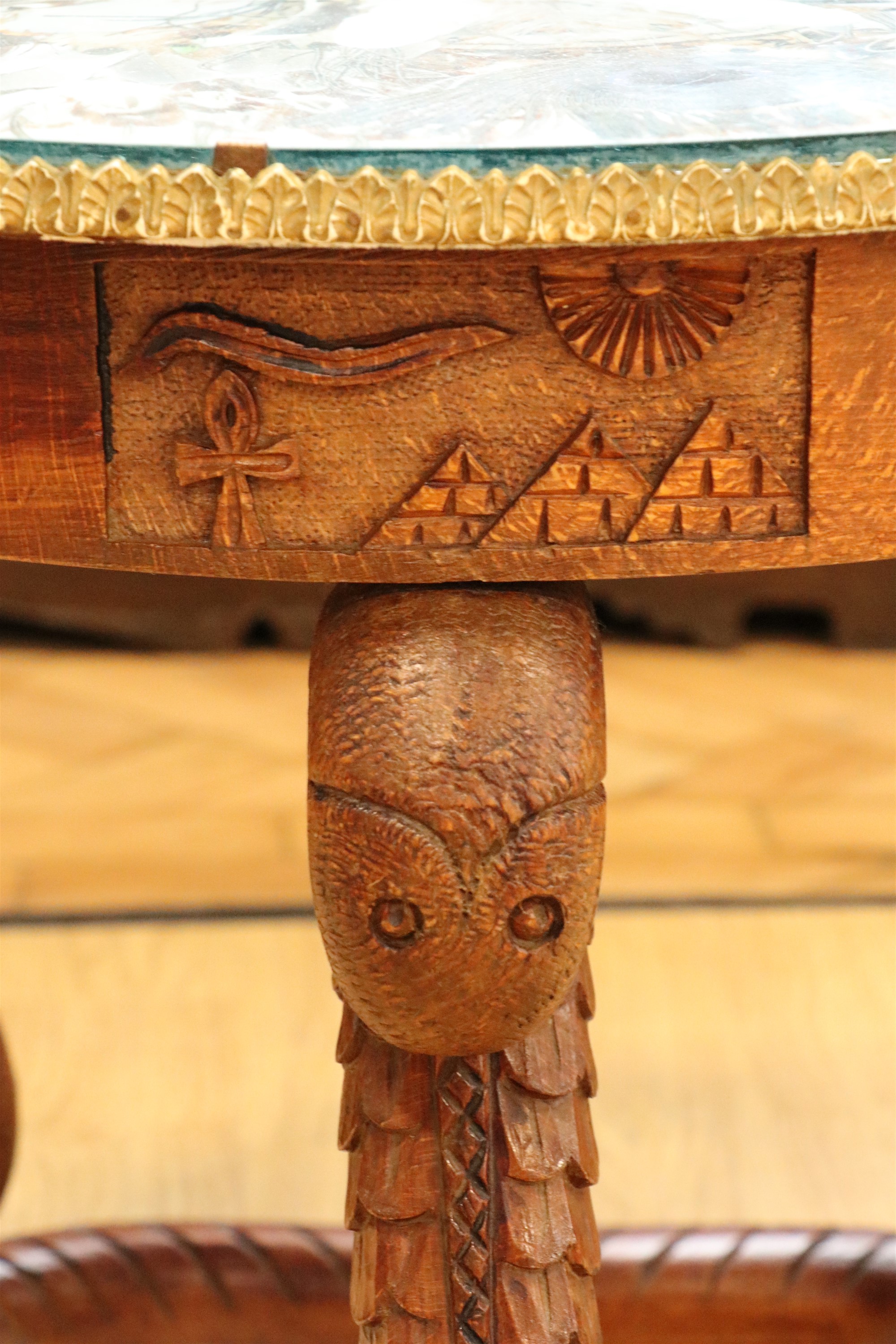 An Egyptian carved hardwood coffee table, having serpent-form legs and a glass and peacock feather - Image 3 of 4