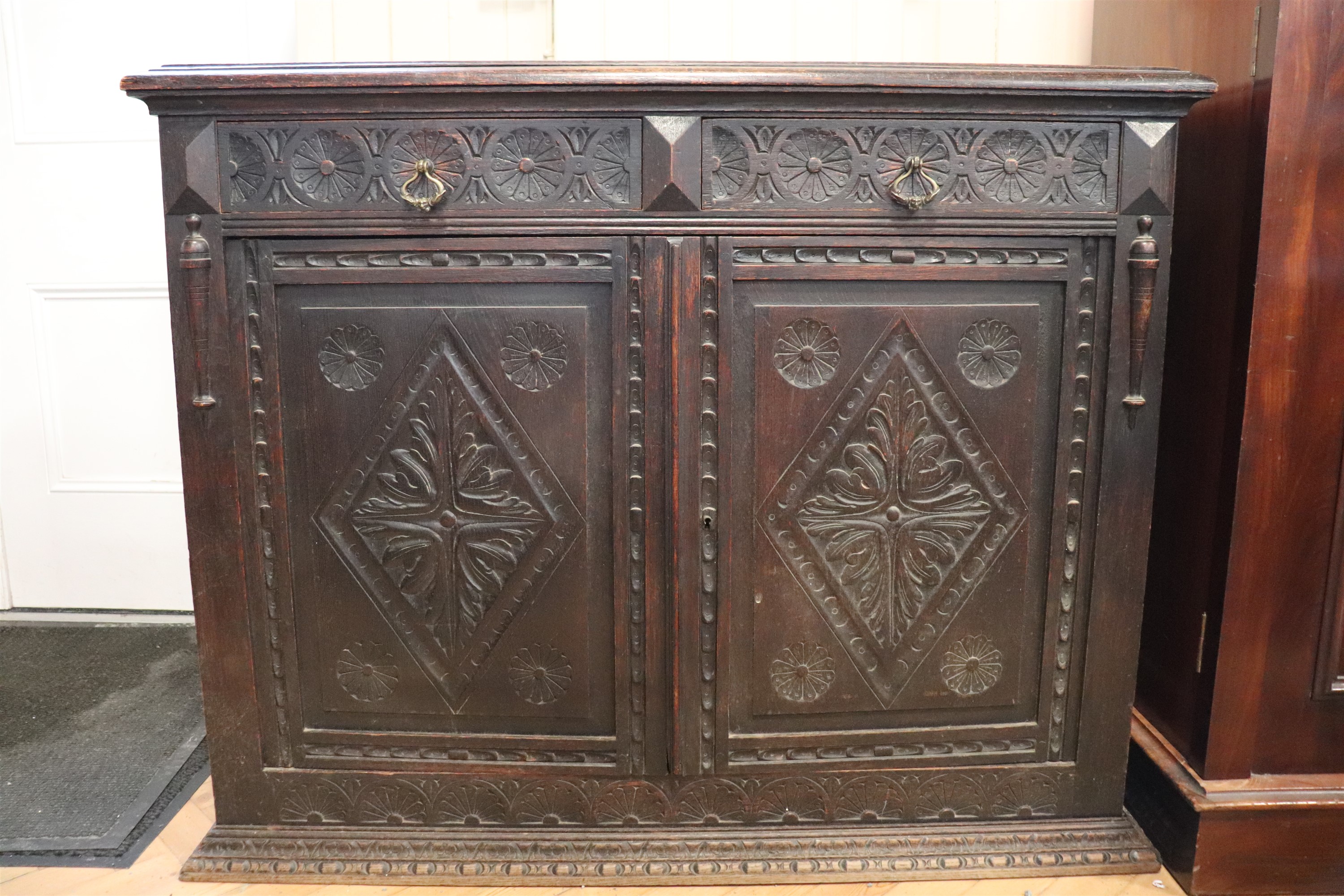 A late 19th / early 20th Century carved oak side cabinet, 130 cm x 49 cm x 101 cm