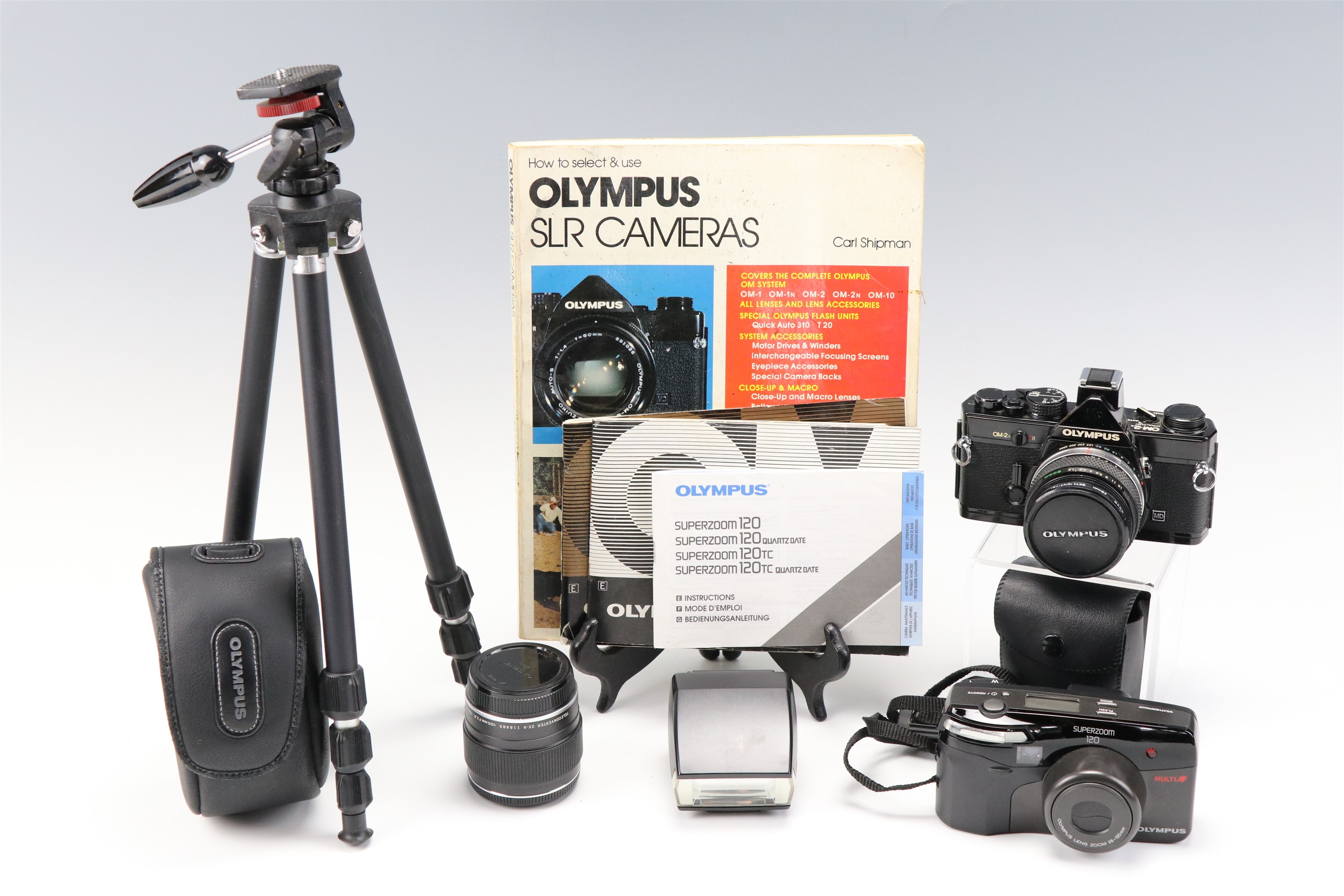 An Olympus OM-2 camera body together with a 1:1,8 f = 50mm lens, a Teleconverter 2X-A lens, a
