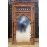 An Asian heavy carved wooden framed wall mirror, late 20th Century, 84 cm x 45 cm