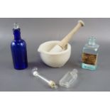 A mortar and pestle together with a cobalt blue glass poison bottle, etc