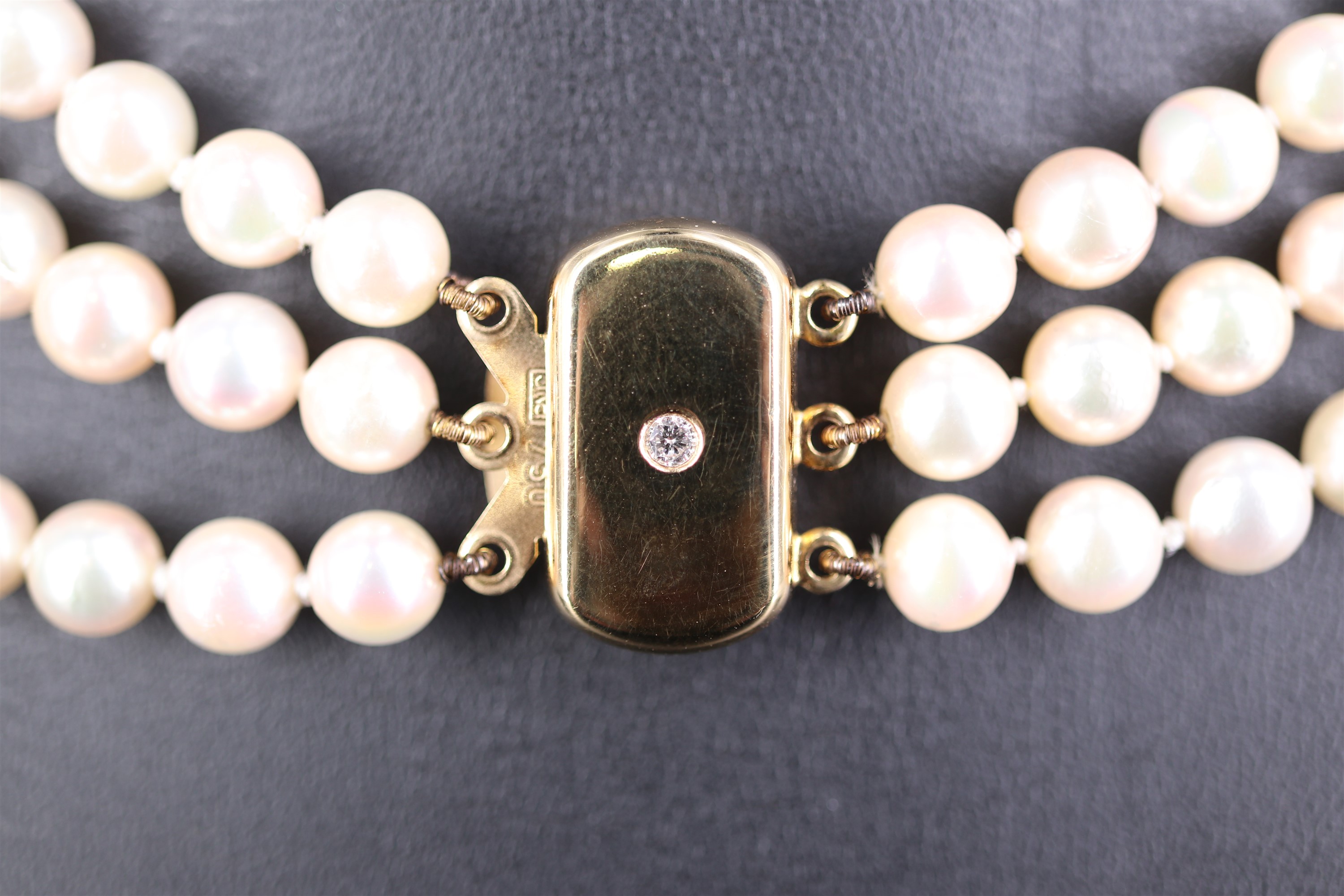 A three-strand necklace of uniform Takara cultured pearls, having an 18 ct gold clasp set with a - Image 2 of 4