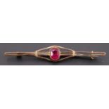 An early 20th Century ruby and 9 ct yellow metal bar brooch, the oval cut stone of approx 1 ct, 63