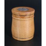 A small carved wooden pot, the lid inset with a silver disk bearing Celtic decoration, Thomas
